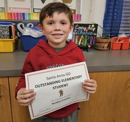 young student holding Outstanding Elementary Student paper